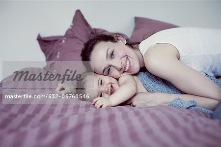 Mother and infant lying on bed
