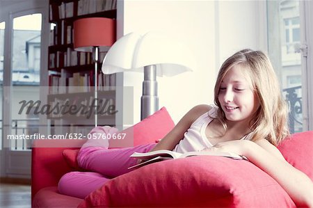 Girl relaxing on couch reading book