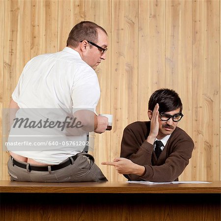 Businessman ignoring colleague at desk in office