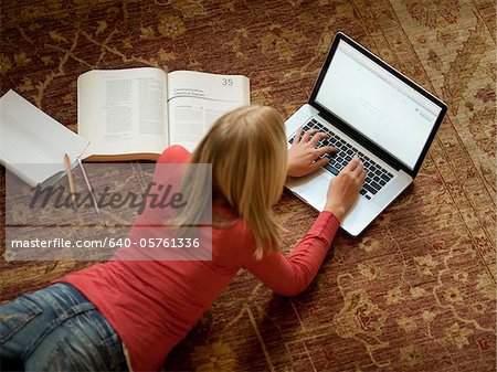 USA, Utah, Cedar Hills, Teenage Mädchen (14-15) auf Boden, liegend mit laptop