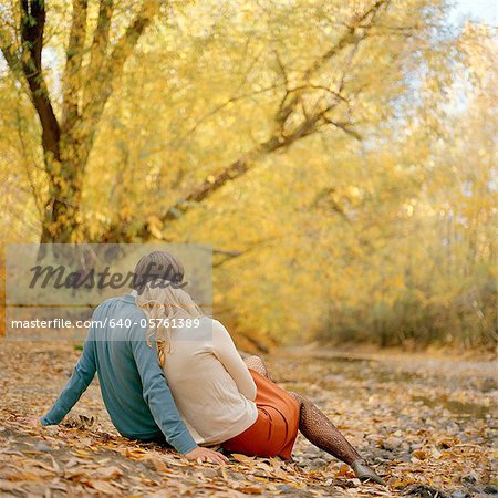 USA, Utah, Salt Lake City, Young couple sitting together in autumn park, rear view