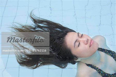 Femme flottant dans la piscine