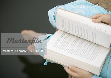 Child reading book, high angle view