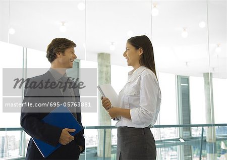 Männliche und weibliche Geschäftskollegen stehen, sprechen
