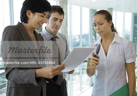 Business colleagues standing, discussing document