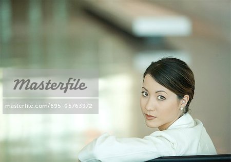 Woman, looking over shoulder at camera