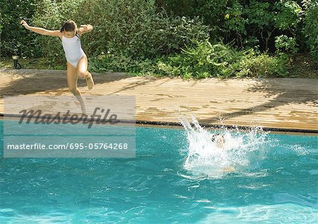 Children jumping into swimming pool