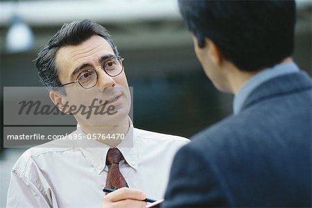 Businessmen talking face to face, head and shoulders