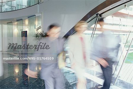 Business executives walking in lobby, blurred motion
