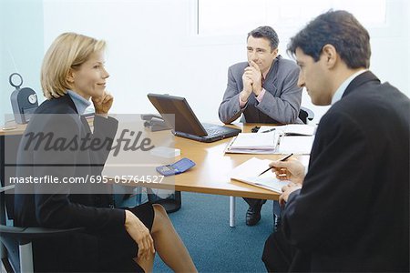 Professional couple sitting in meeting with sales executive
