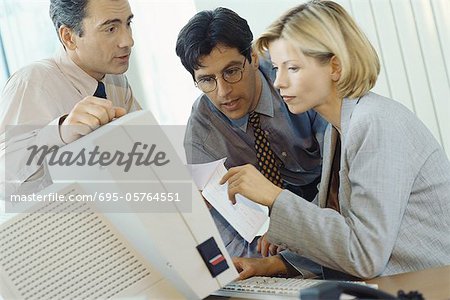 Business associates working at desktop computer