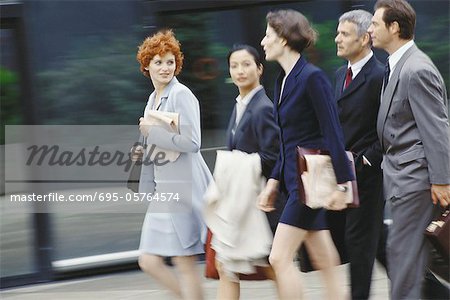 Group of business executives walking, blurred motion