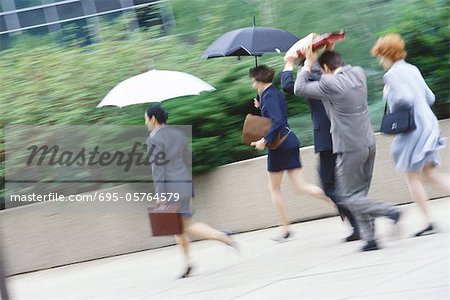 Group of business executives hurrying through rain