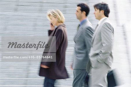 Three business executives walking, blurred motion