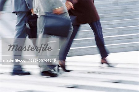 Businesspeople crossing street, low section