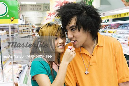Jeune couple en épicerie, femme homme d'alimentation candy