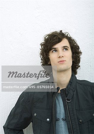 Young man looking up, portrait, white background