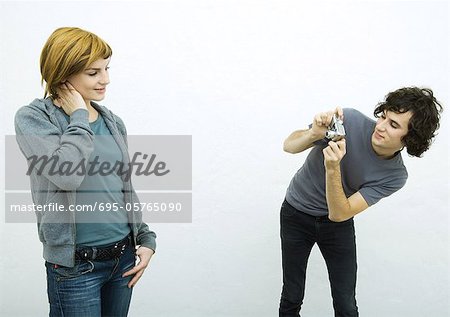 Young man taking photo of young woman