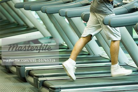 Man running on treadmill, waist down