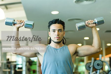 Man lifting dumbbells, waist up, front view