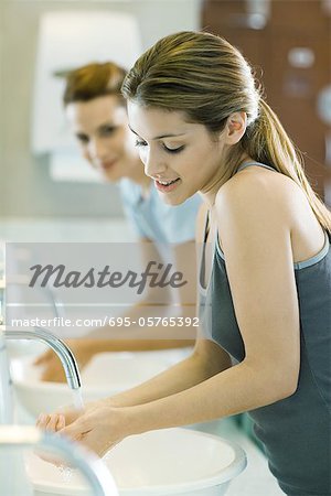 Two women washing hands in public restrooms