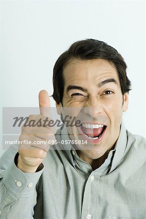 Homme donnant thumbs up sign, clin d'oeil, portrait