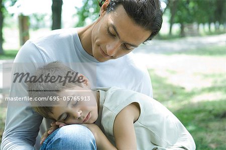 Boy and father, boy sleeping in man's lap