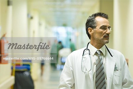 Männlichen Arzt Wegsehen, Krankenhaus Korridor im Hintergrund