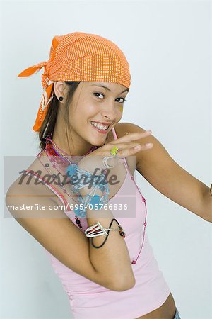 Teenage girl wearing lots of jewelry, smiling at camera, portrait