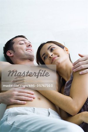 Young couple reclining together, smiling