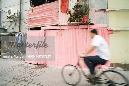 Chine, Province du Guangdong, Guangzhou, vélo à travers la rue de l'homme