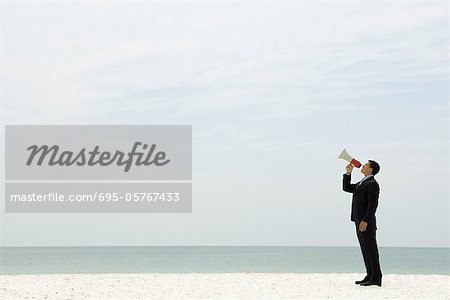 Unternehmer stehen am Strand in Megaphon schrie