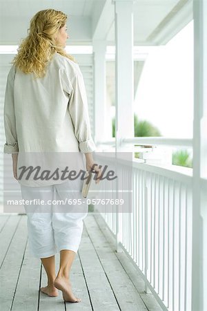 Femme qui marche sur le porche, livre comptable, vue arrière