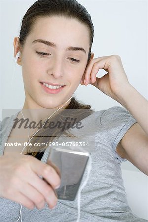Teen Mädchen anhören der MP3-Player, Lächeln, Blick nach unten