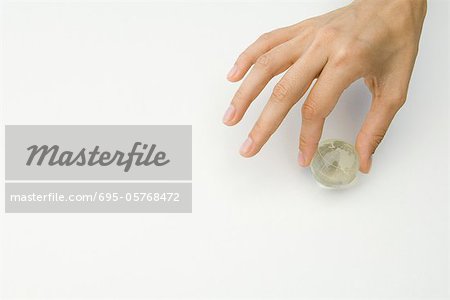 Hand holding tiny globe, cropped view Hand holding tiny globe, cropped view
