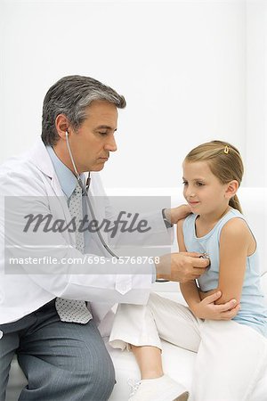 Doctor listening to girl's heart with stethoscope