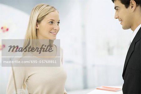 Homme et femme face à face au comptoir, souriant à l'autre