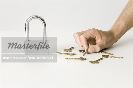 Main en choisissant clé pour gros cadenas