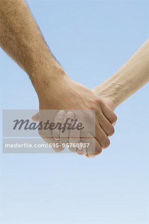 Couple holding hands, cropped view