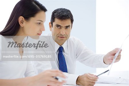 Businessman showing document to female associate