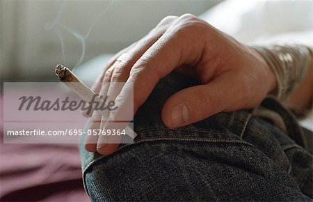 Hand holding smoking joint