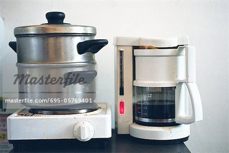 Steamer on hotplate next to coffee maker on counter