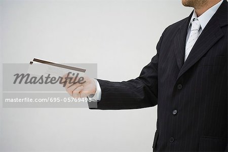 Man in suit holding out tickets, side view