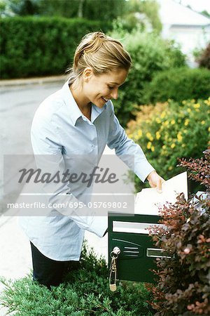 Woman checking mail, smiling