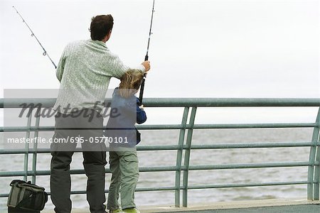 Père et fils de pêche de la jetée, de père fils de coup avec sa canne à pêche