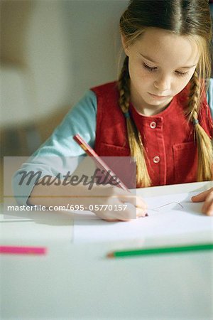 Little girl drawing with colored pencils