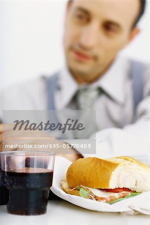 Businessman focusing on work, lunch in foreground