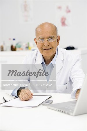 Doctor at desk completing paperwork