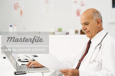 Doctor at desk busy with paperwork