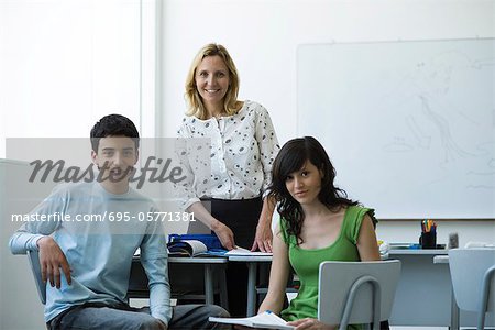 Teacher and high school students together in classroom, portrait